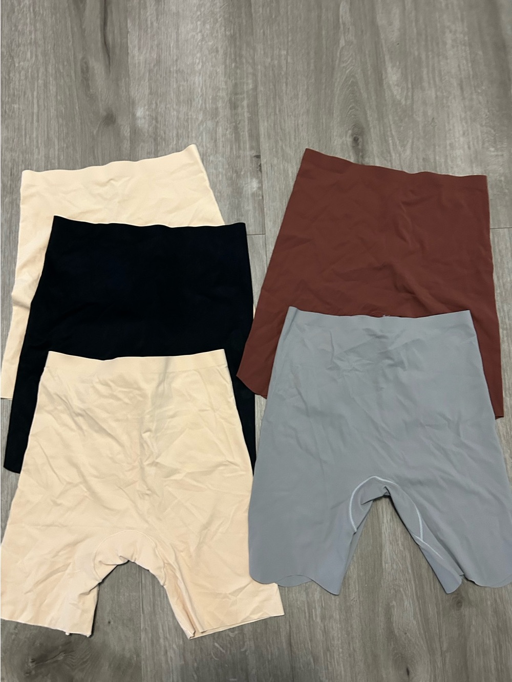 5 pack of Skims shapewear shorts in black, beige, brown, and gray